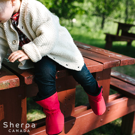 petite fille dans un paysage d'automne sur une table de pique-nique et portant des bottines de la collection Moki de Sherpa Canada